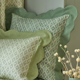Cushions in a green and neutral printed linen fabric with a geometric pattern