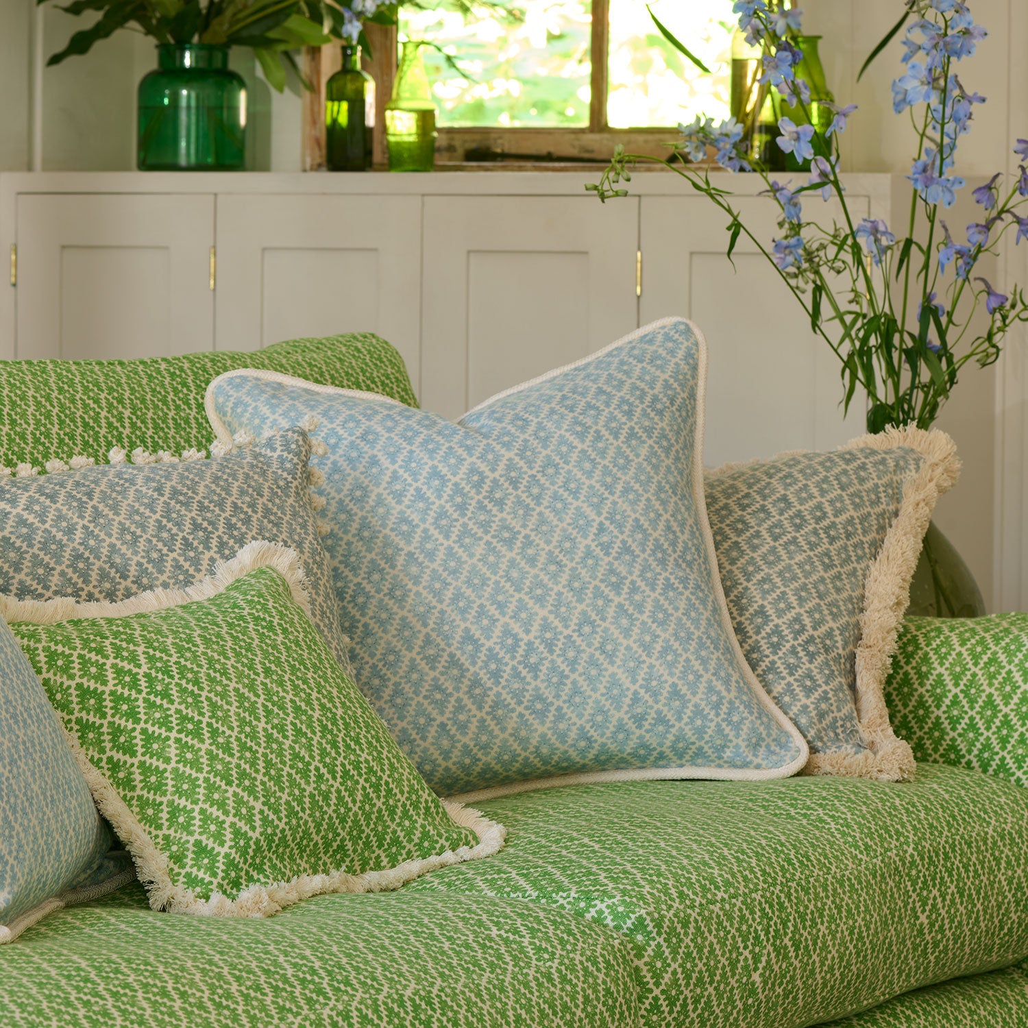 Sofa upholstered in a green and neutral printed linen fabric with a geometric pattern