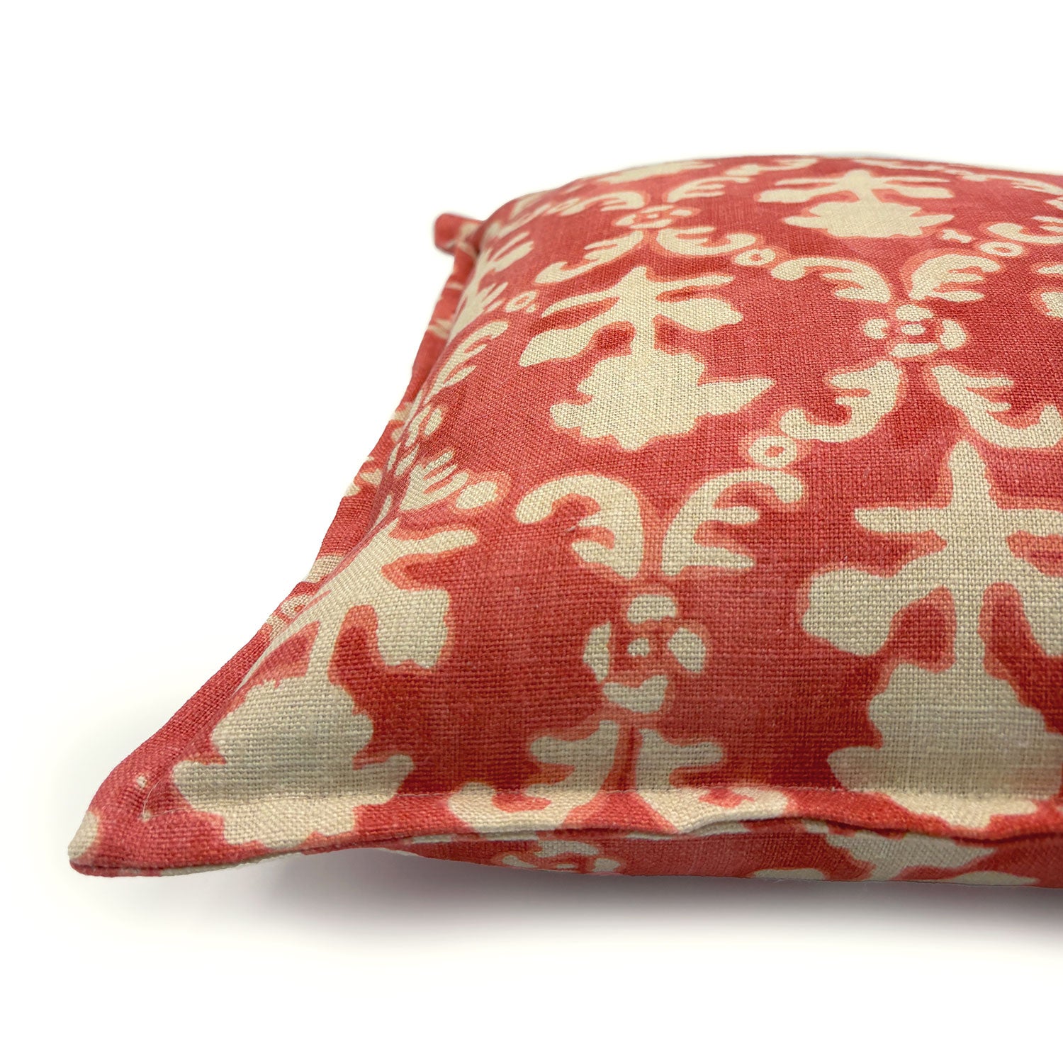 Decorative pillow with red and ivory floral pattern.
