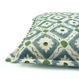 Decorative cushion with a geometric floral pattern in blue and green.