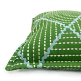 Green cushion with geometric blue pattern.