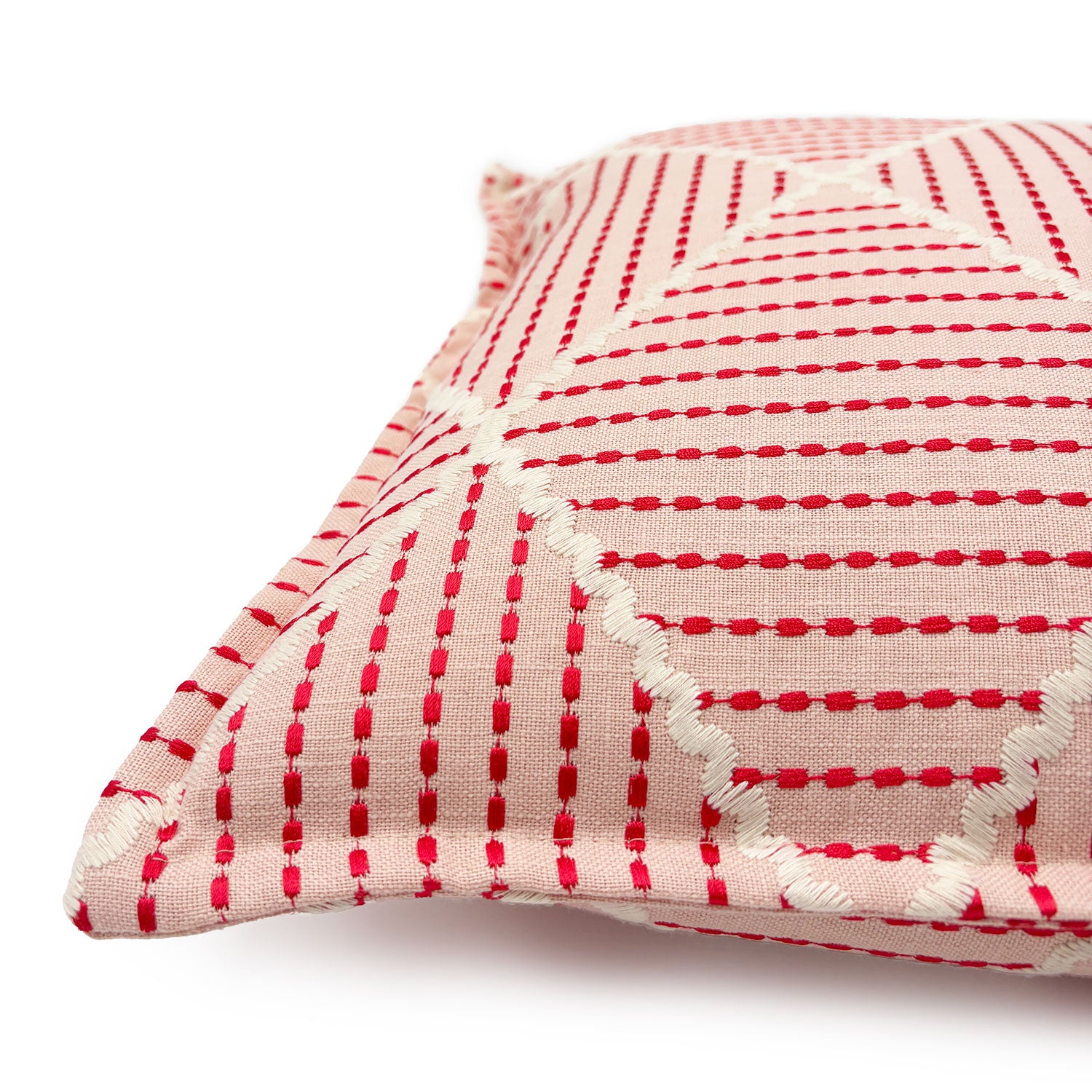 Pink cushion with geometric red pattern.