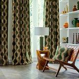 Curtains and cushion in a printed velvet fabric in green and orange featuring a stylized fern pattern.