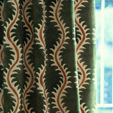 Curtain in a printed velvet fabric in green and orange featuring a stylized fern pattern.
