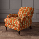 Armchair upholstered in a printed velvet fabric in brown and orange featuring a stylized fern pattern.
