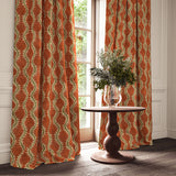 Curtains in a printed velvet fabric in brown and orange featuring a stylized fern pattern.