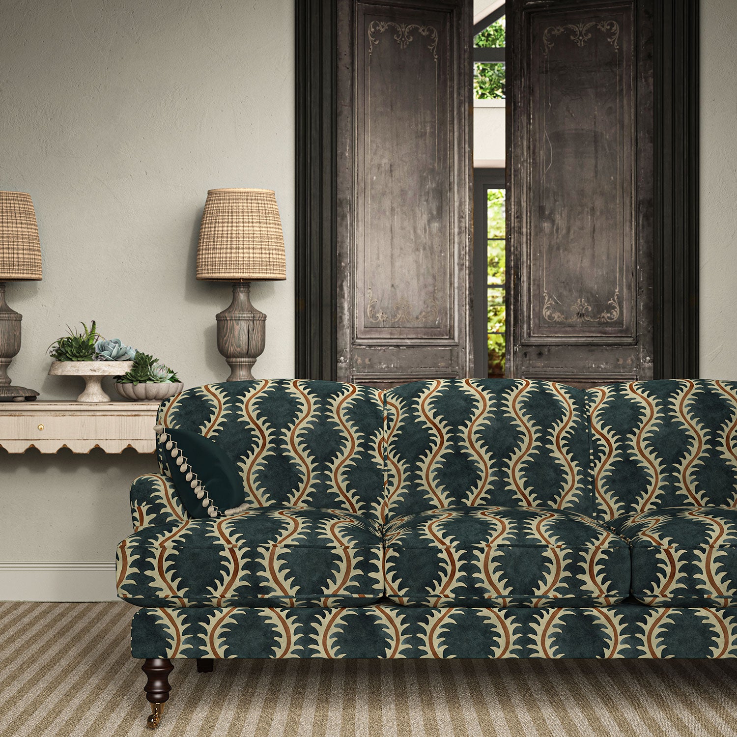 Sofa upholstered in a printed velvet fabric in blue and orange featuring a stylized fern pattern.