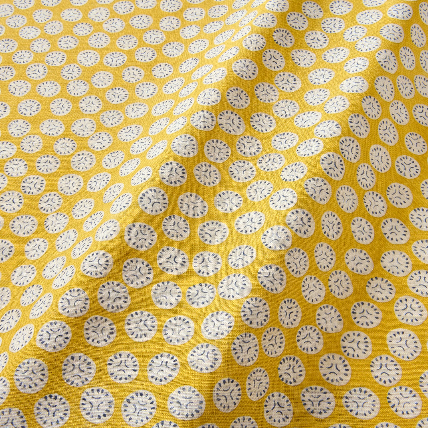 A linen printed with a subtle all-over repeat in yellow, cream and black