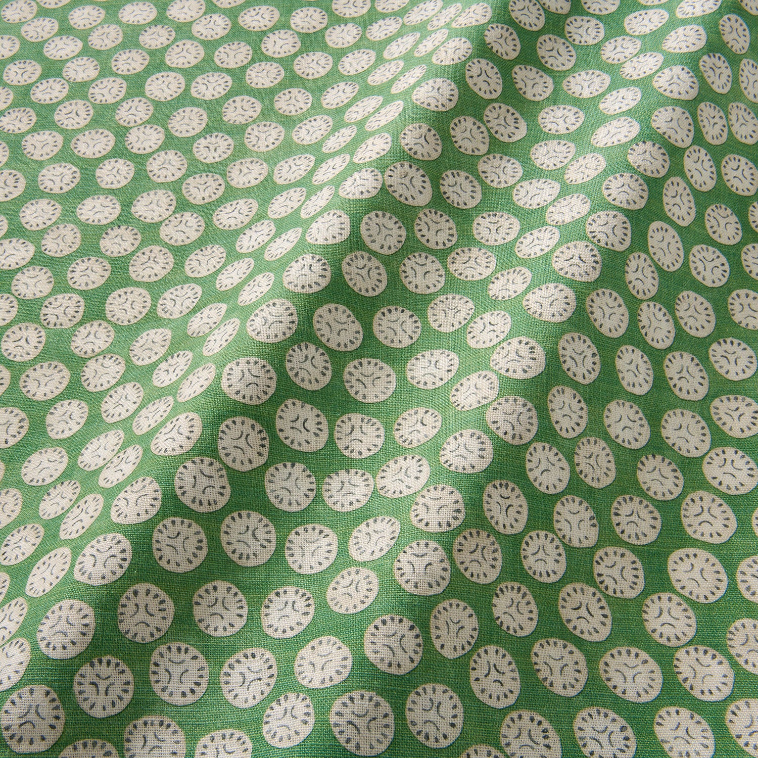 A linen printed with a subtle all-over repeat in green, cream and black