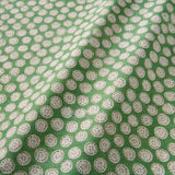 A linen printed with a subtle all-over repeat in green, cream and black