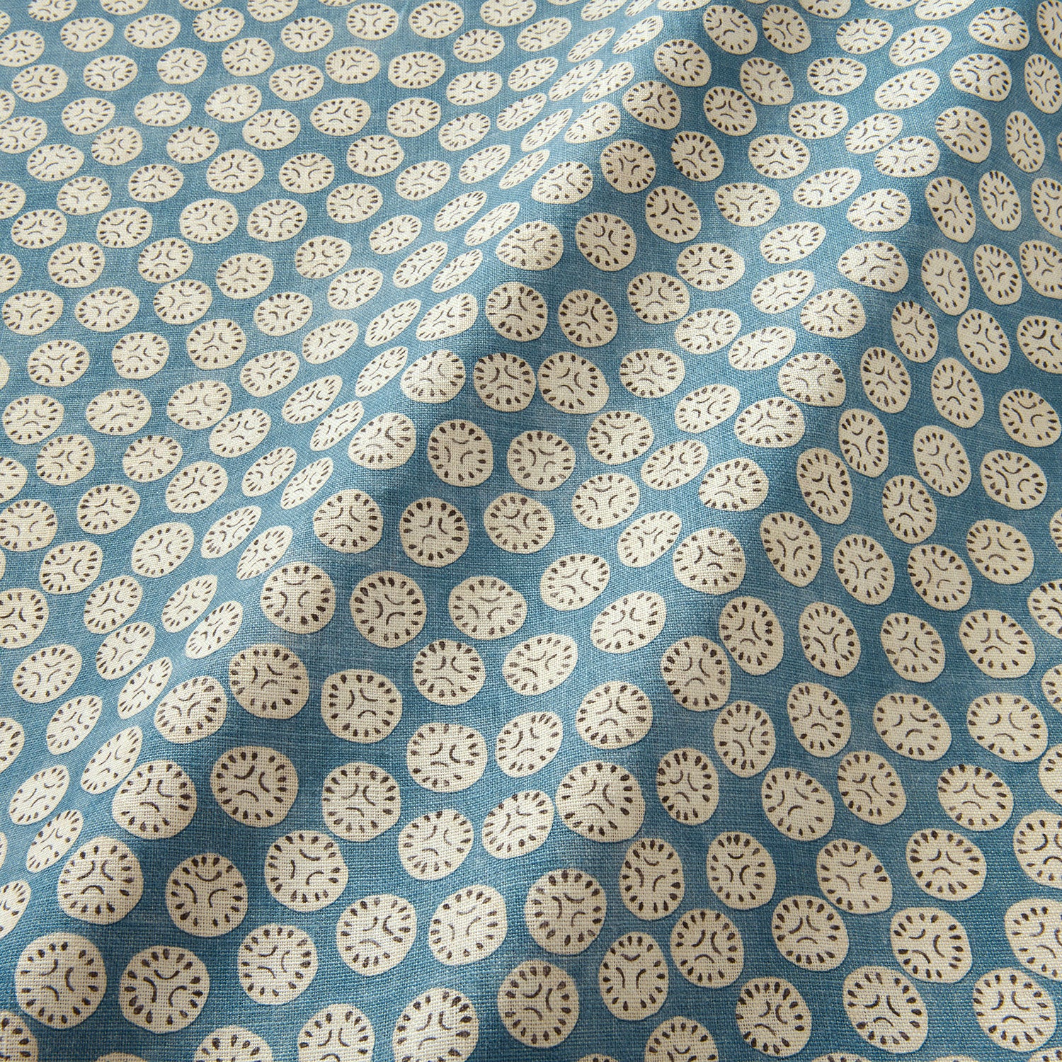 A linen printed with a subtle all-over repeat in blue, cream and black