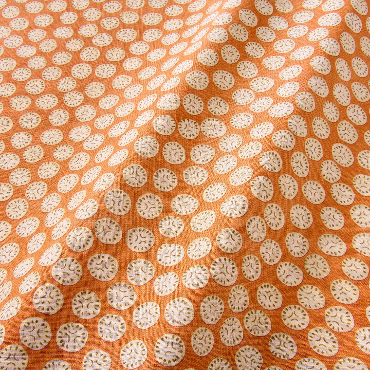 A linen printed with a subtle all-over repeat in orange, cream and black