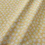 A linen printed with a subtle all-over repeat in yellow, cream and black