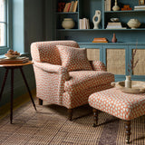 Armchair covered in a linen printed with a subtle all-over repeat in orange, cream and black