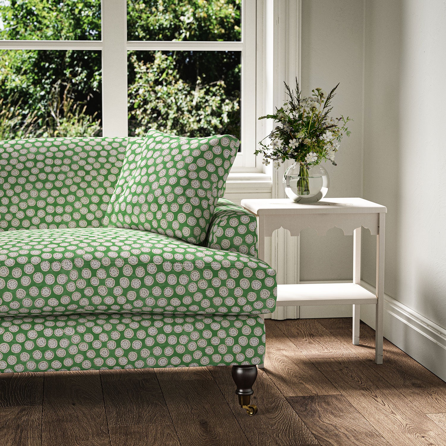Sofa covered in a linen printed with a subtle all-over repeat in green, cream and black