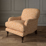 Armchair covered in a linen printed with a subtle all-over repeat in orange, cream and black