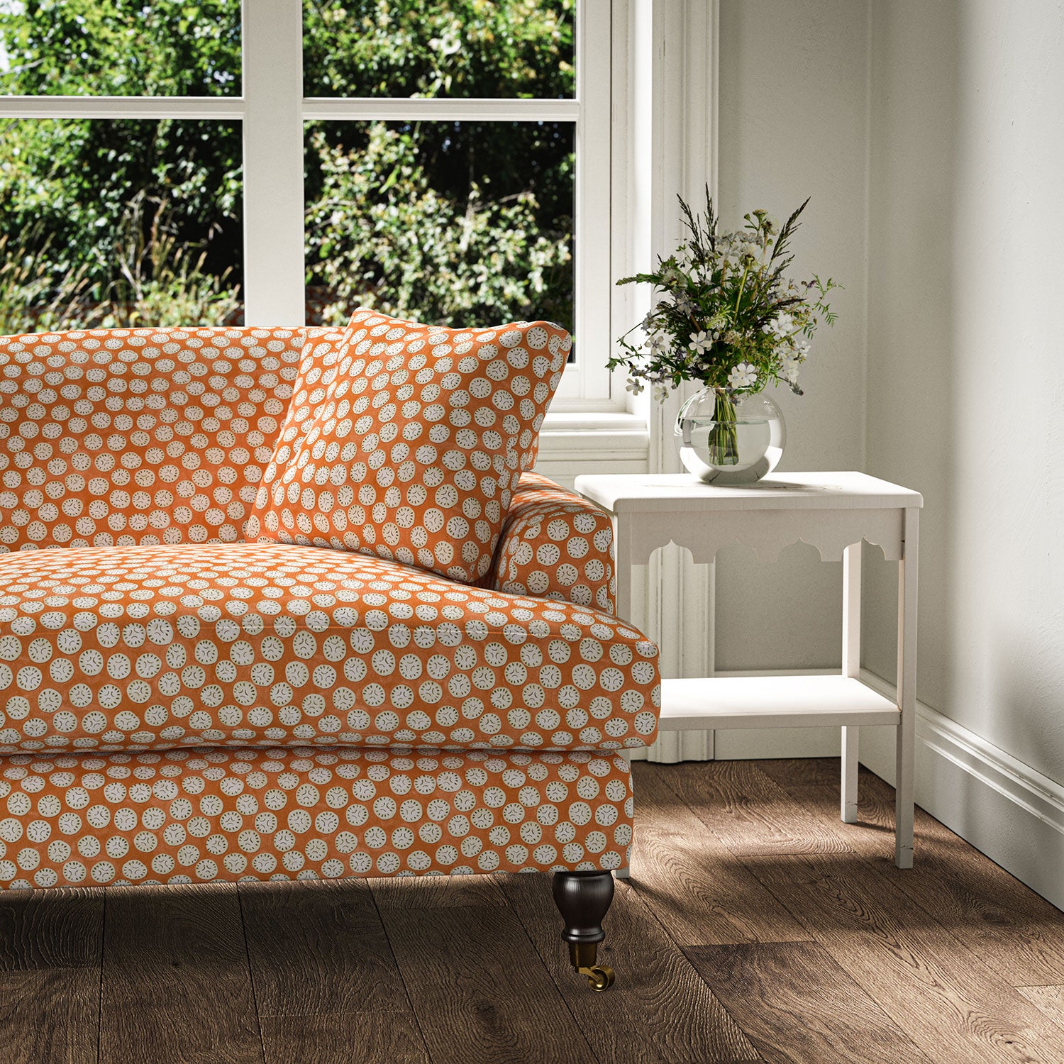 Sofa covered in a linen printed with a subtle all-over repeat in orange, cream and black