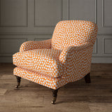 Armchair covered in a linen printed with a subtle all-over repeat in orange, cream and black