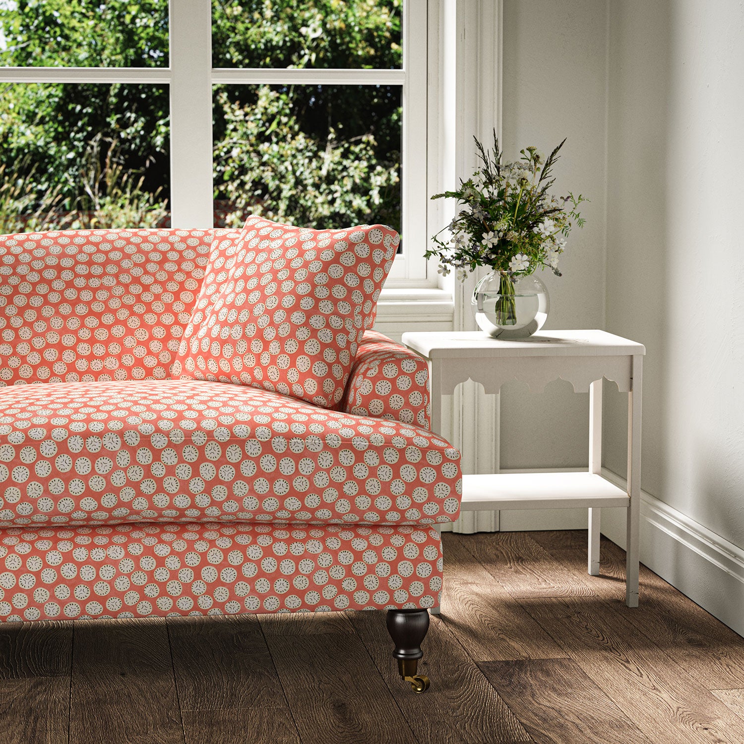 Sofa covered in a linen printed with a subtle all-over repeat in pink, cream and black