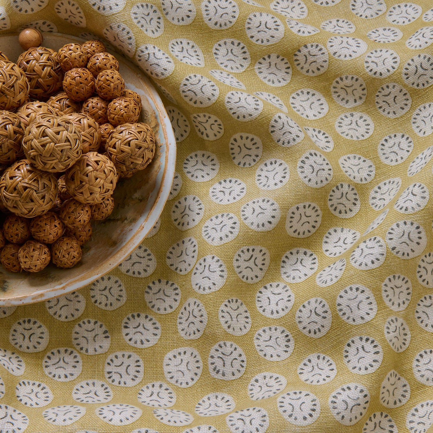 A linen printed with a subtle all-over repeat in yellow, cream and black