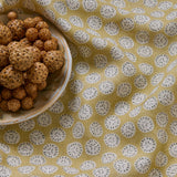 A linen printed with a subtle all-over repeat in yellow, cream and black