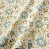 A stylised floral printed on linen fabric in green, orange and cream