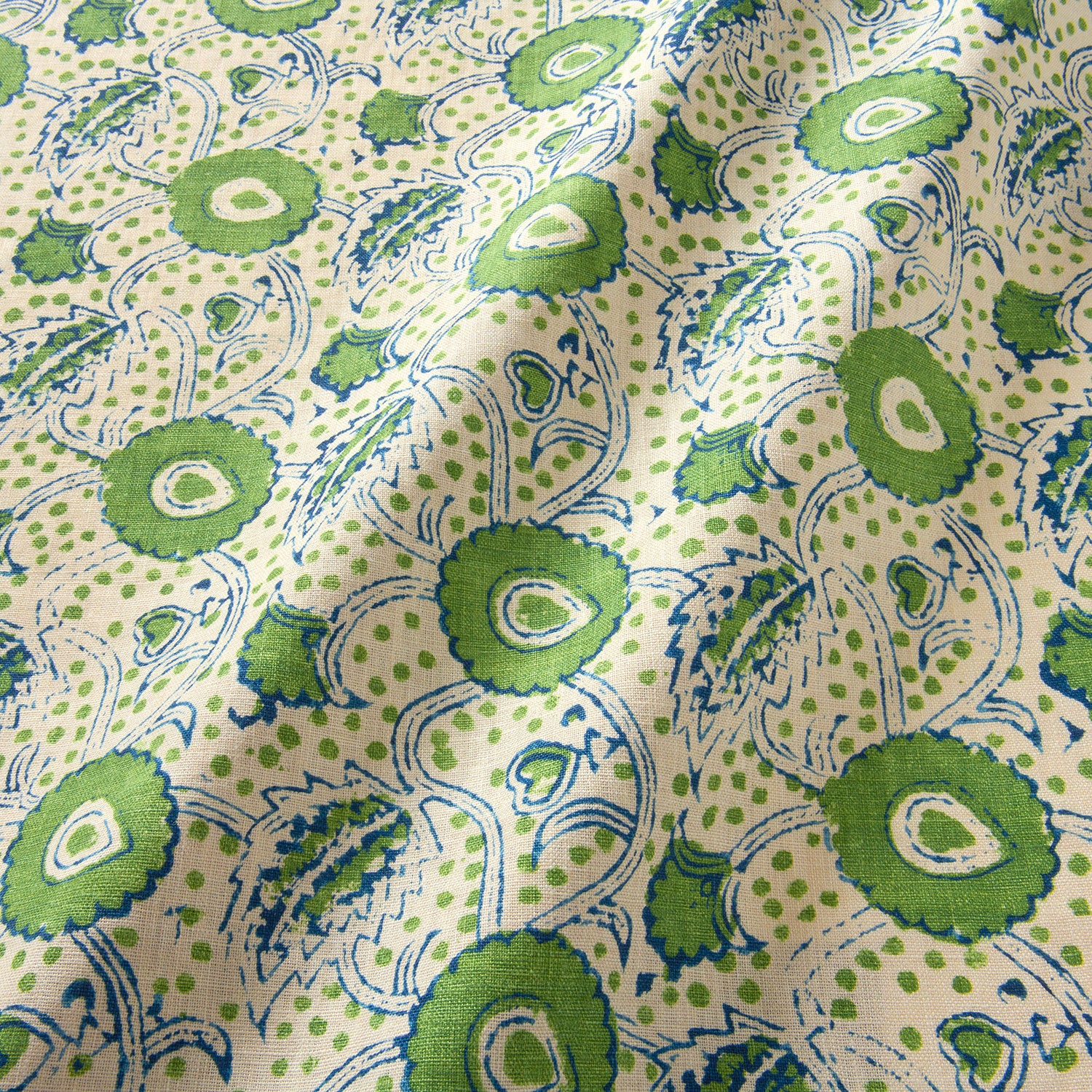 A stylised floral printed on linen fabric in green, blue and cream