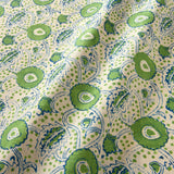 A stylised floral printed on linen fabric in green, blue and cream