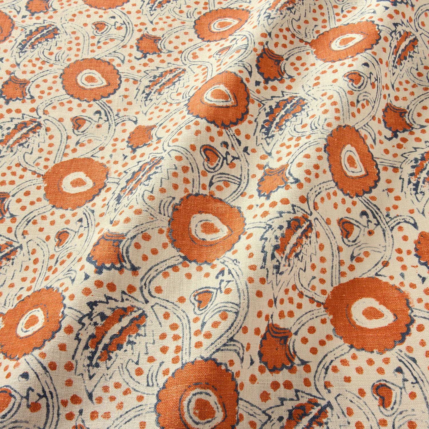 A stylised floral printed on linen fabric in red, blue and cream