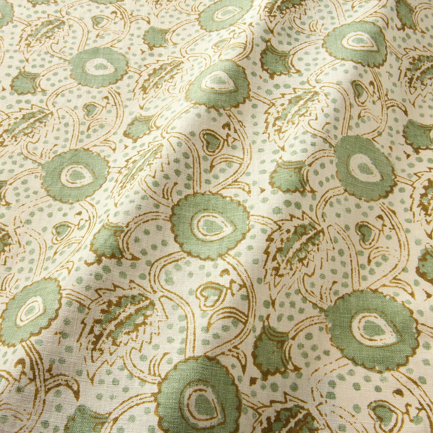 A stylised floral printed on linen fabric in green, orange and cream