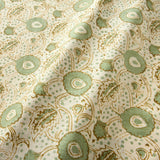A stylised floral printed on linen fabric in green, orange and cream