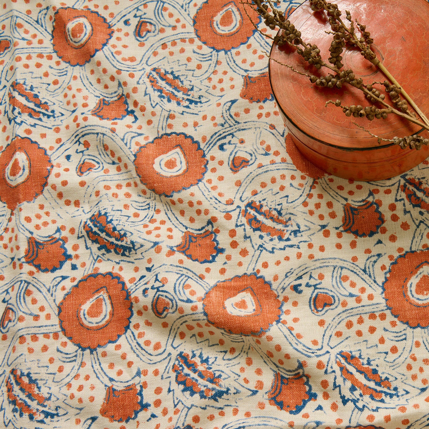 A stylised floral printed on linen fabric in red, blue and cream