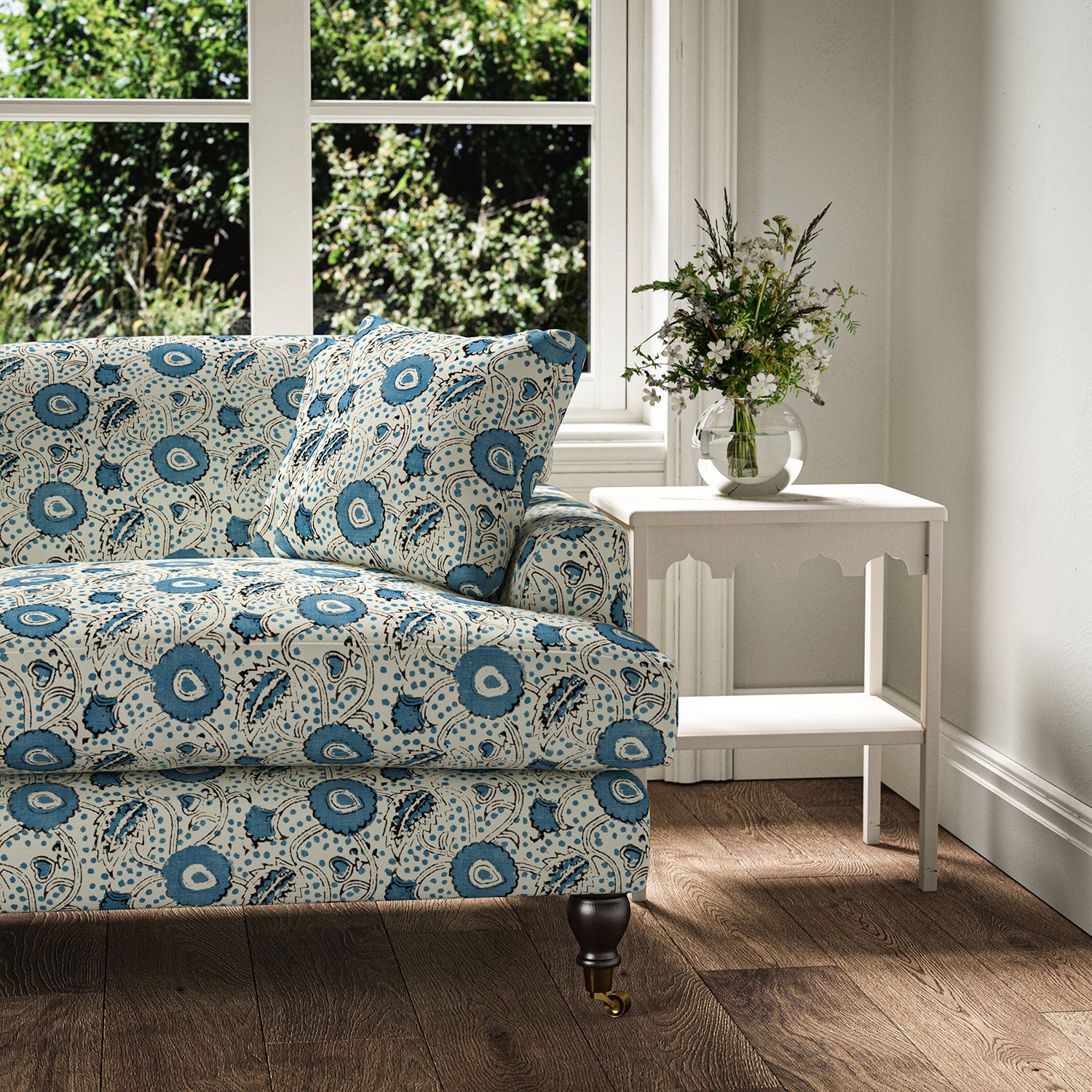Sofa covered with a stylised floral printed on linen fabric in blue, black and cream