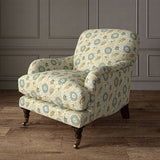 Armchair covered with a stylised floral printed on linen fabric in green, orange and cream