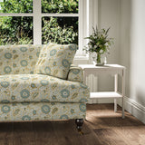 Sofa covered with a stylised floral printed on linen fabric in green, orange and cream