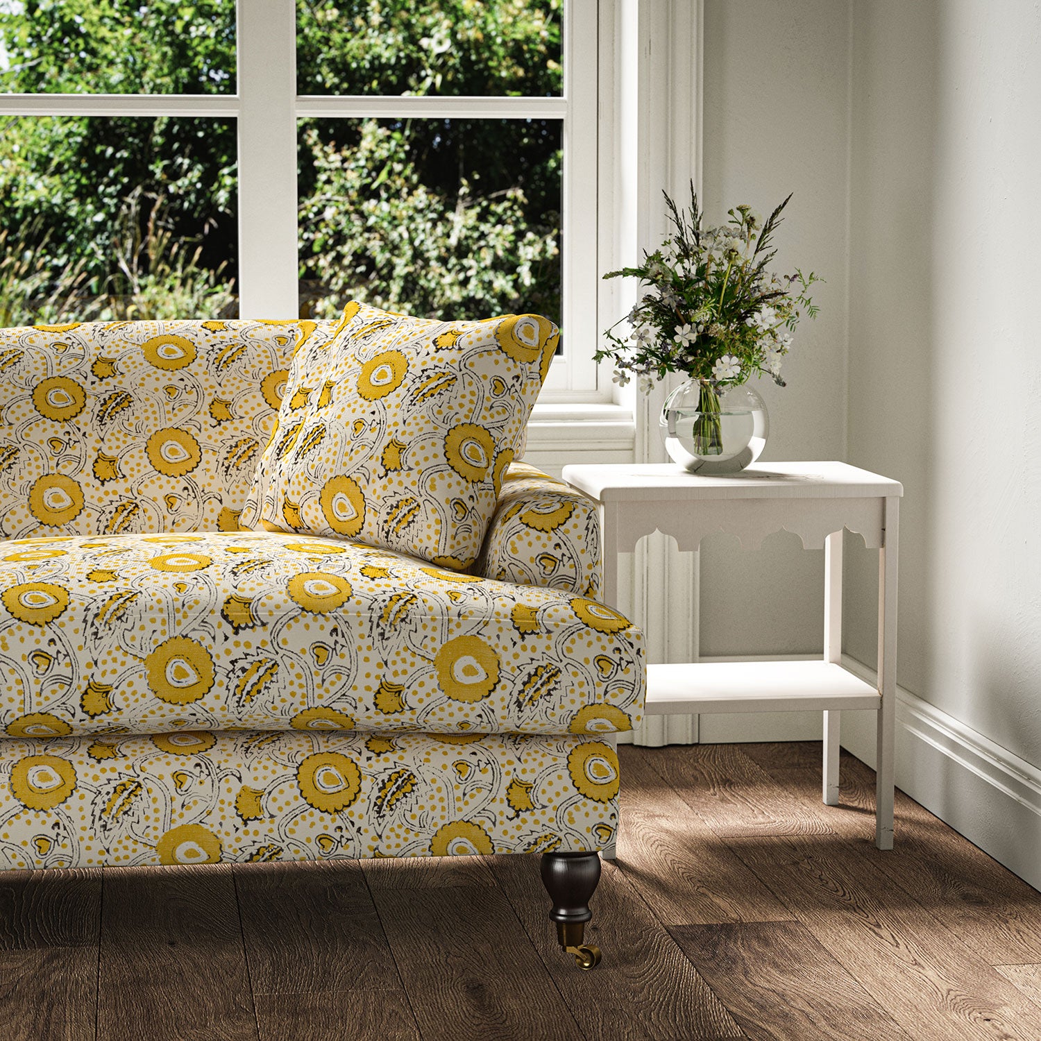 Sofa covered with a stylised floral printed on linen fabric in yellow, black and cream