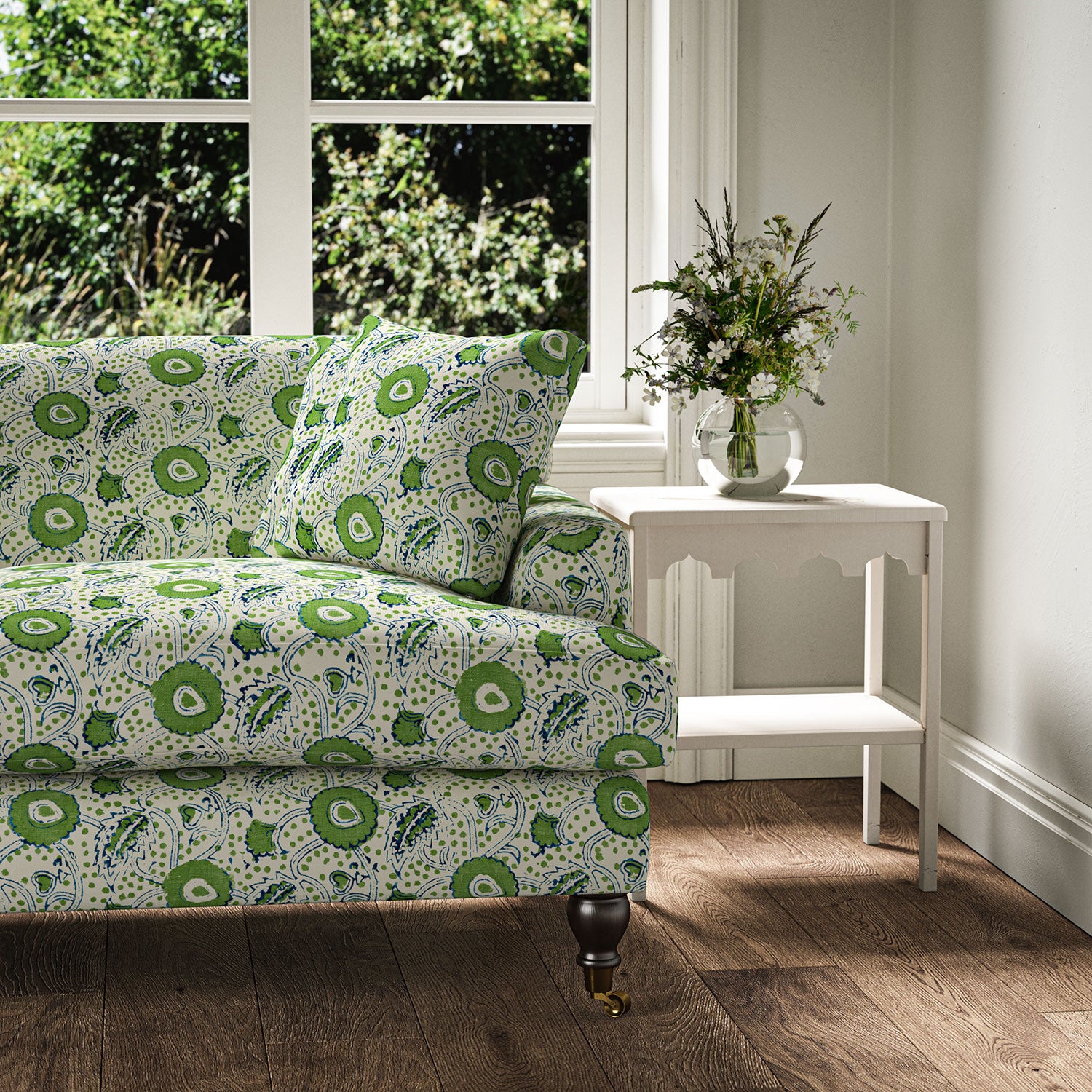 Sofa covered with a stylised floral printed on linen fabric in green, blue and cream