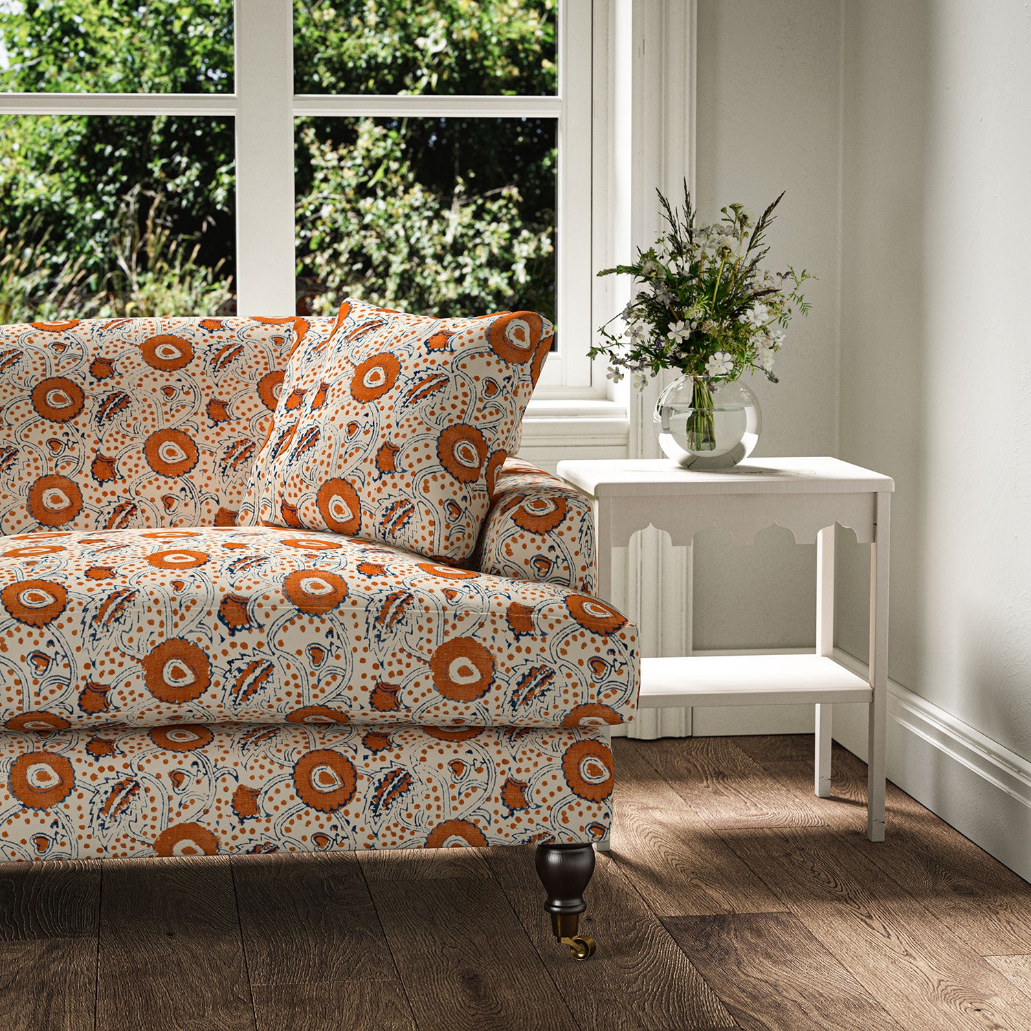 Sofa covered with a stylised floral printed on linen fabric in red, blue and cream