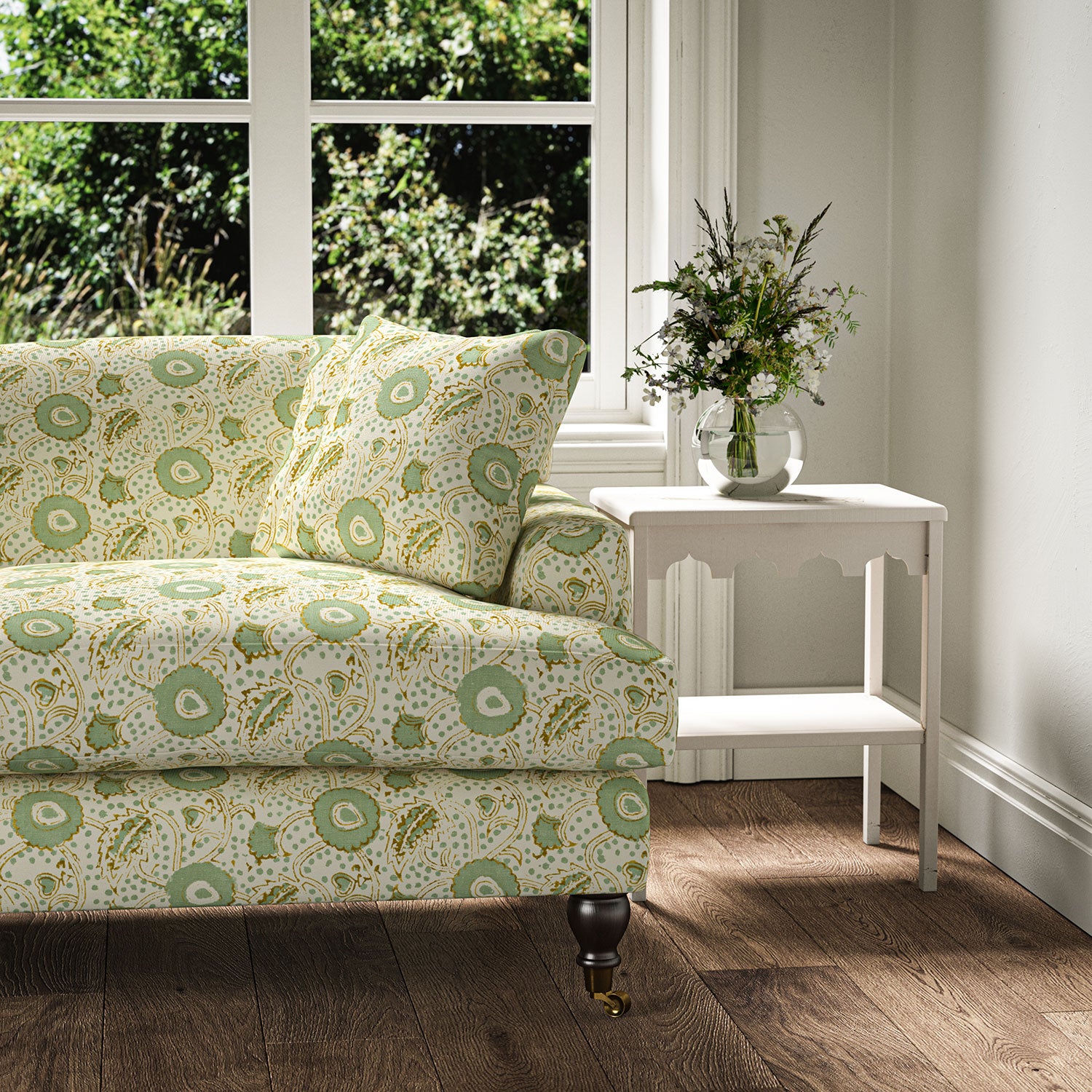 Sofa covered with a stylised floral printed on linen fabric in green, orange and cream