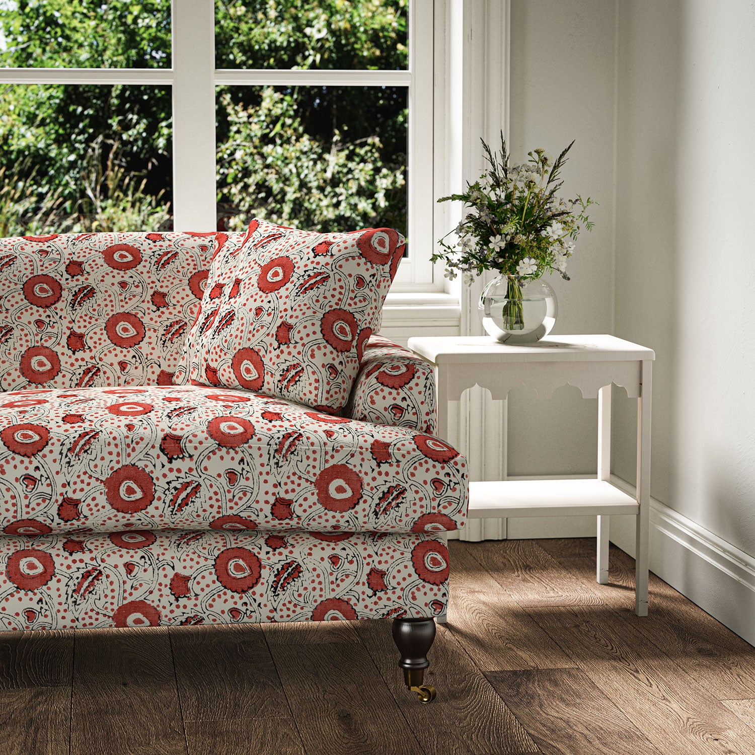 Sofa covered with a stylised floral printed on linen fabric in red, black and cream