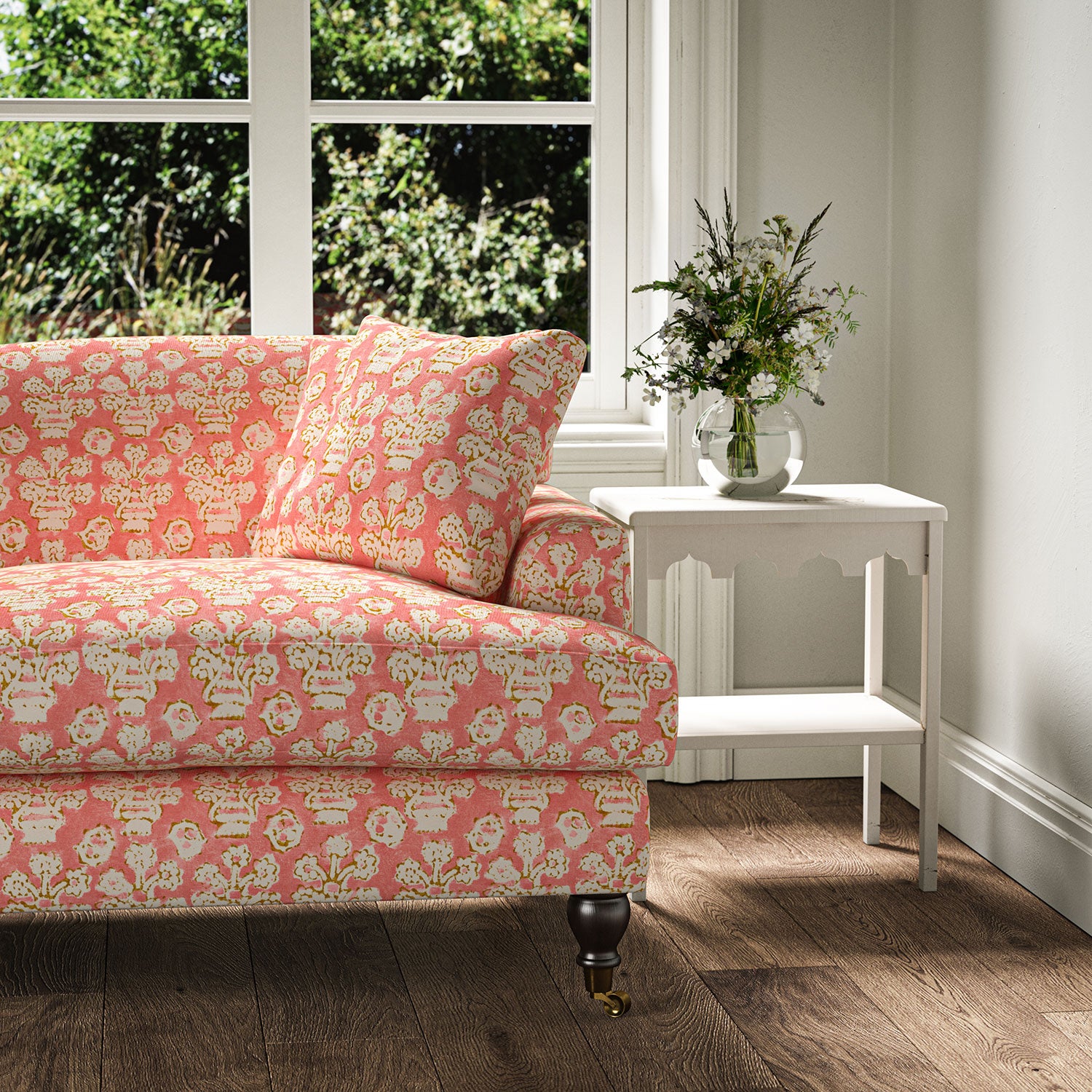 Sofa covered in a jolly printed linen fabric in pink, orange and cream