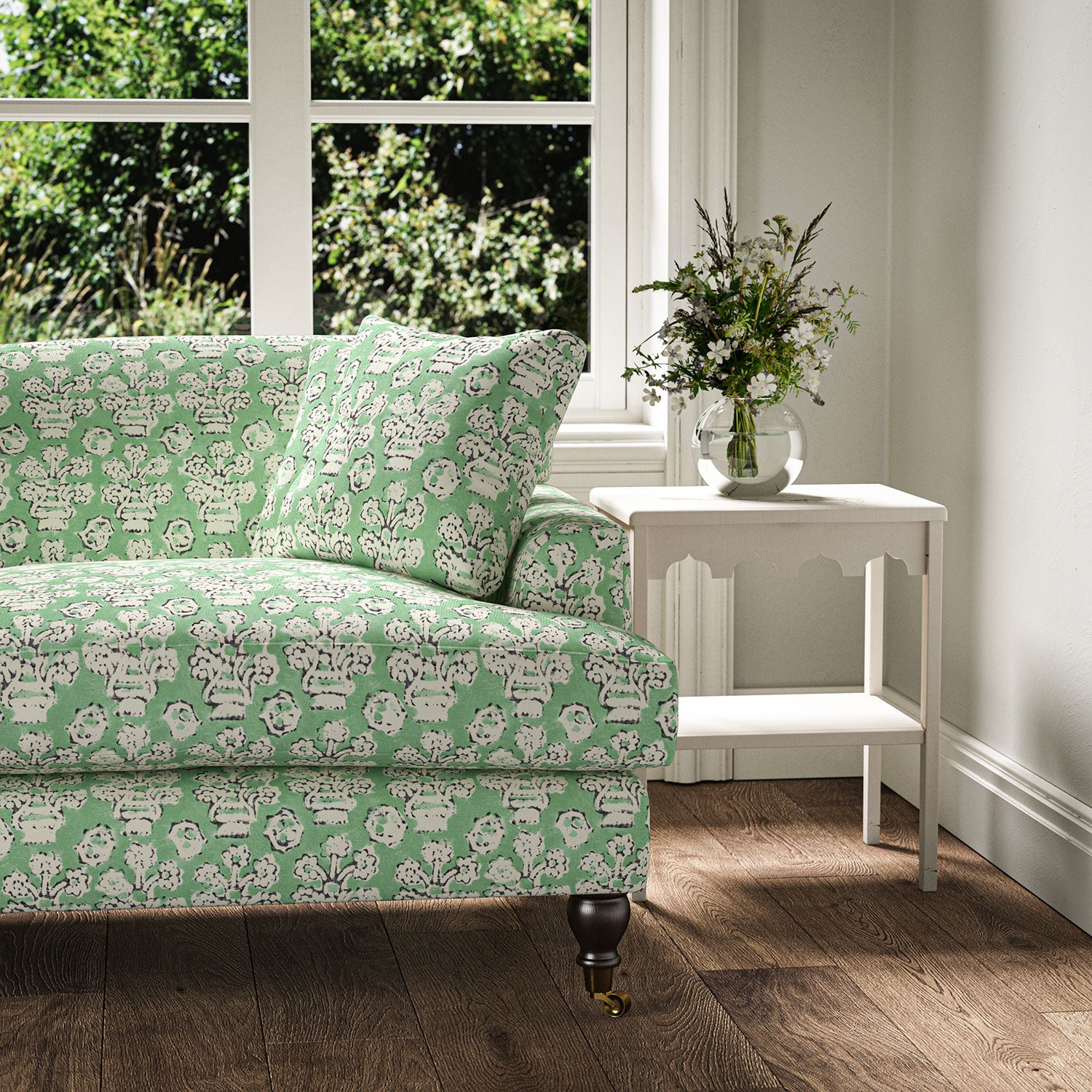 Sofa covered in a jolly printed linen fabric in green, black and cream