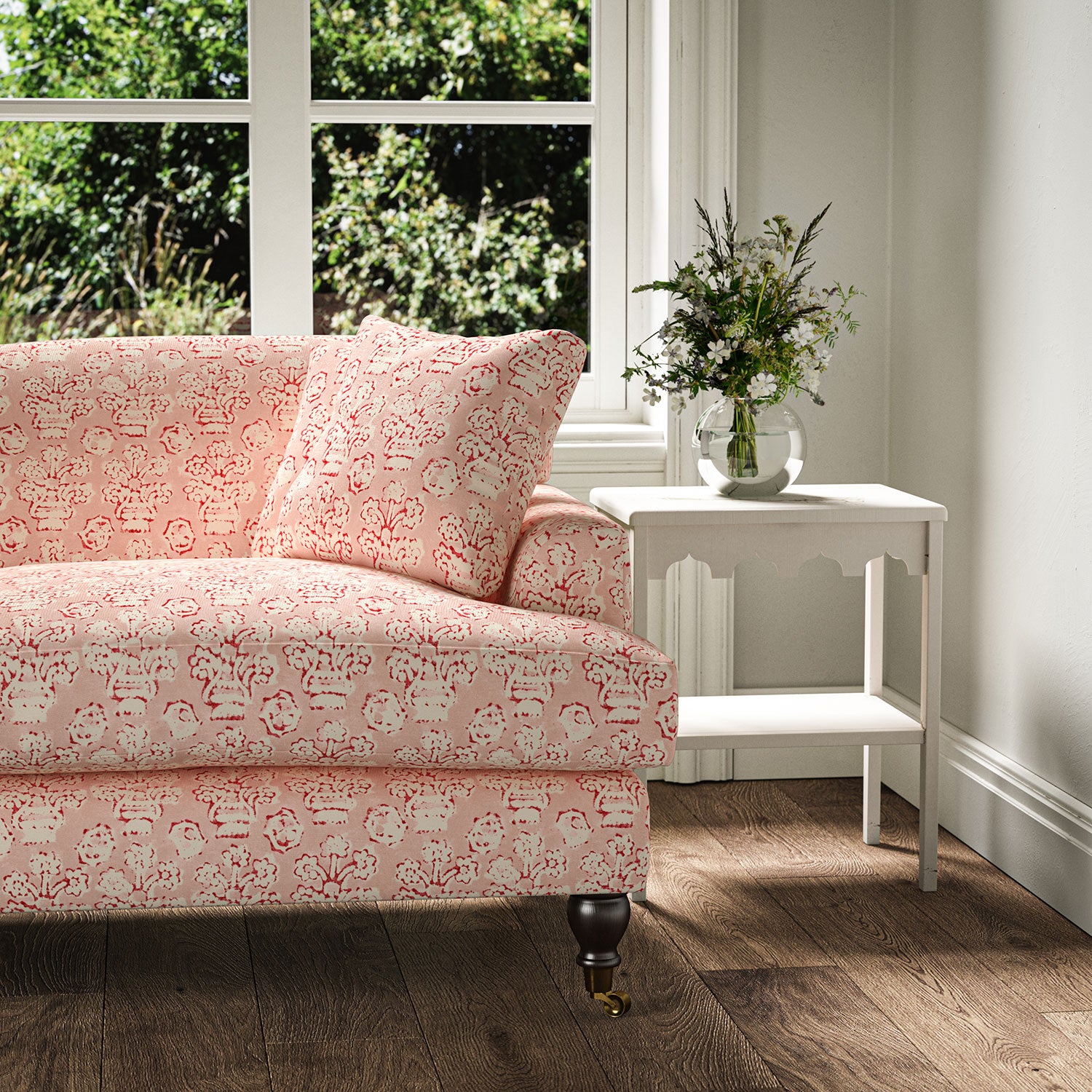 Sofa covered in a jolly printed linen fabric in pink, red and cream