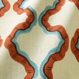 A printed linen fabric sample in blue, orange, brown and off white featuring a mirrored ribbon pattern.
