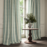 Curtains made from a printed linen fabric in blue and off white, featuring a striped fern design.