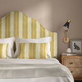 Headboard upholstered in a printed linen fabric in yellow and off white, featuring a striped fern design.
