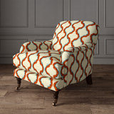 Armchair upholstered in a printed linen fabric in blue, orange, brown and off white featuring a mirrored ribbon pattern.