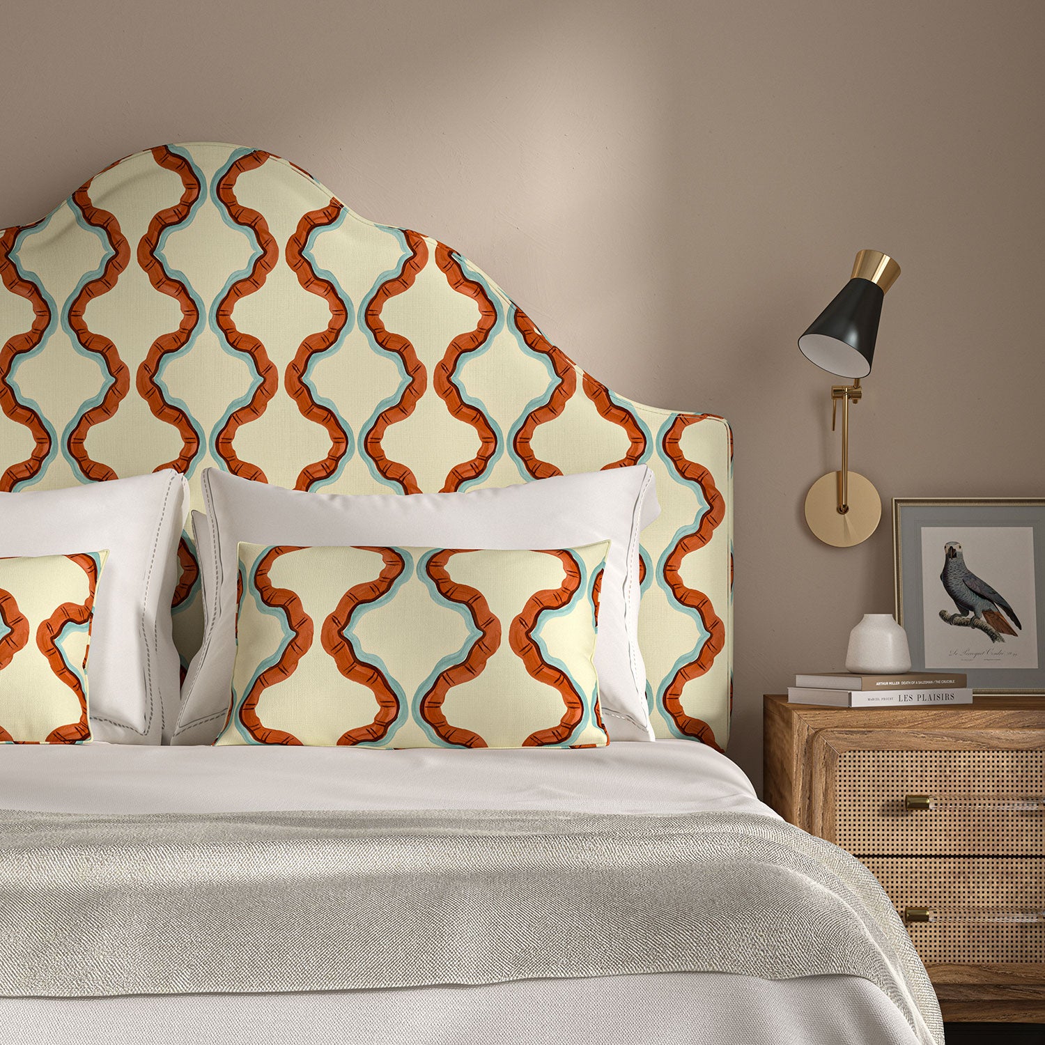 Headboard upholstered in a printed linen fabric in blue, orange, brown and off white featuring a mirrored ribbon pattern.