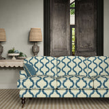 Sofa upholstered in a printed linen fabric in blue and off white featuring a mirrored ribbon pattern.