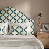 Headboard upholstered in a printed linen fabric in blue and off white featuring a mirrored ribbon pattern.